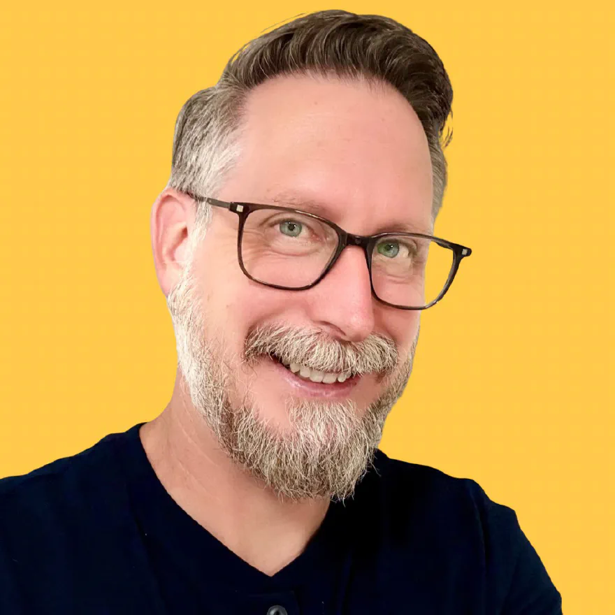 Jay McBride, smiling, in a dark shirt and glasses